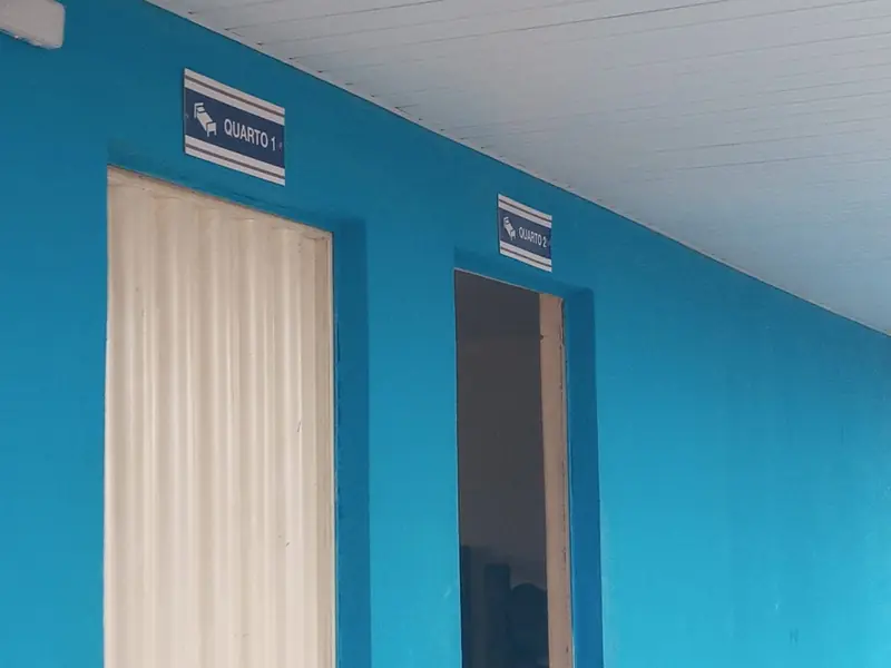 Parede azul com duas portas e as placas Quarto 1 e Quarto 2